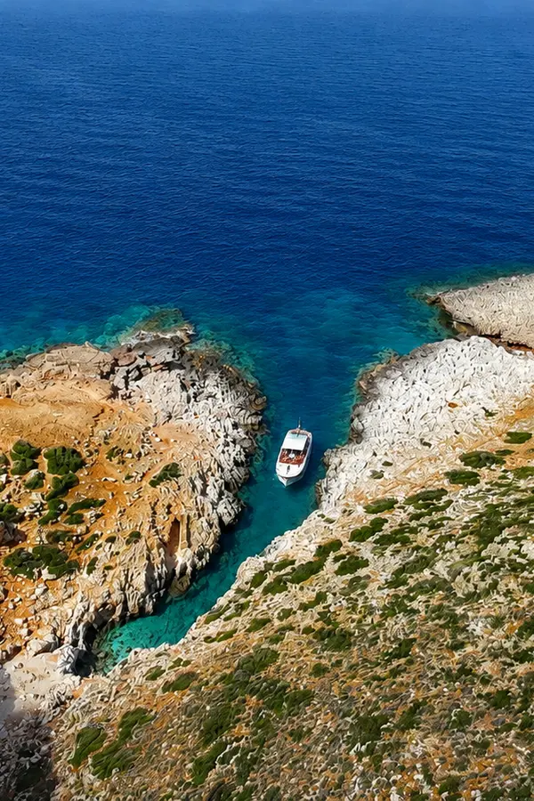 Steep cliffs, turquoise coves, and clear sea characterize Katholiko bay on the western coast of Crete.